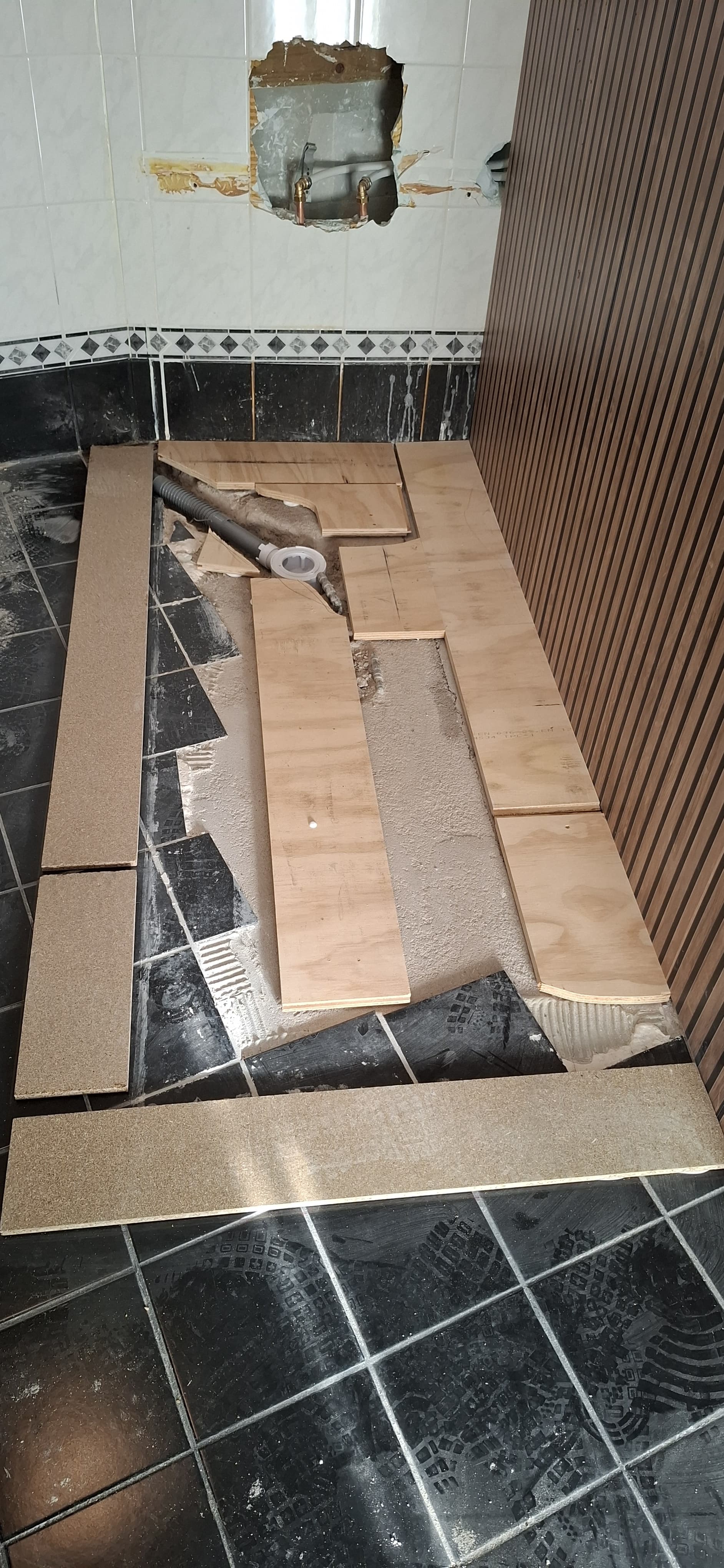 Badkamerrenovatie in uitvoering: voorbereiding voor nieuwe vloer en wandpanelen.